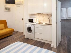una cucina con lavatrice e forno a microonde di Duende RooMalaga by Bossh! Apartments a Málaga