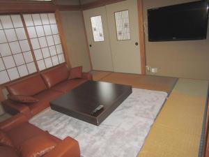 een woonkamer met een bank en een salontafel bij Yuzawa Condo 一棟貸 貴重な駐車場2台無料 in Yuzawa