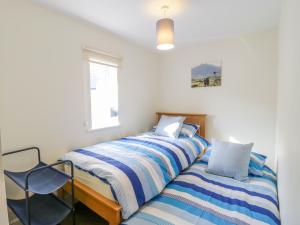 Un dormitorio con dos camas y una silla. en 9 Malthouse Court, en Watchet