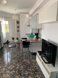 a kitchen with white cabinets and bar stools at Vacacional Tegueste 2ºB in Vecindario +11 photos
