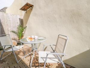 Una mesa y dos sillas en un patio. en 9 Malthouse Court, en Watchet