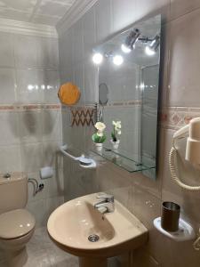 uma casa de banho com um lavatório, um WC e um espelho. em Vacacional Tegueste 2ºA em Vecindario