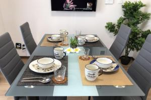 a dining room table with two chairs and a table with cups and plates at TerraceRin YN33 in Tomigusuku