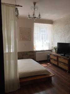 a bedroom with a bed and a flat screen tv at Heart of Lviv in Lviv