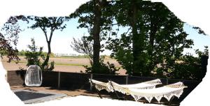 two hammocks sitting next to a fence with trees at Byonz in Groningen