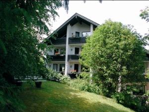 a large white house on top of a grassy hill at Hotel Berghof in Willingen