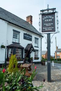 una señal frente a un edificio blanco en The Carden Arms en Tilston