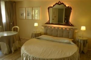 a bedroom with a large bed and a large mirror at Il Cardo Resort in Anghiari