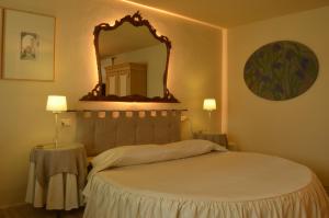 a bedroom with a large bed and a mirror at Il Cardo Resort in Anghiari