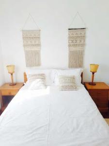 1 dormitorio con 2 camas con sábanas blancas y 2 lámparas en BEACH-SURF house en Moledo