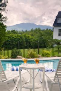 a table with two glasses on it next to a pool at Sugar Hill Inn in Sugar Hill