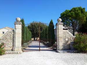 une porte menant à une maison dotée d'une clôture en pierre dans l'établissement Le Figuier, à Tulette