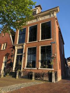 a red brick building with windows on a street at B&B Diepzicht in Dokkum