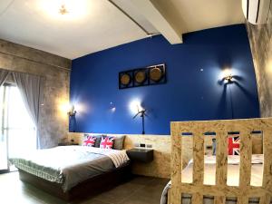 Schlafzimmer mit blauen Wänden und einem Bett mit einem Kopfteil aus Holz in der Unterkunft ALL BLUE in Altstadt von Hengchun