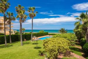a view of a resort with a swimming pool and palm trees at Las Dunas 02 in Denia