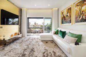 sala de estar con sofá blanco y TV en Ocean View Luxury Suite & Terrace Estoril, Cascias, en Estoril