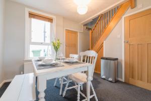 a dining room with a white table and chairs at Marina Beach House in Caister-on-Sea