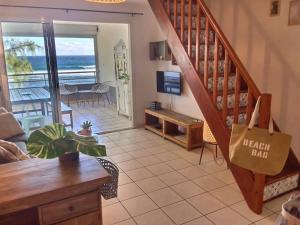 - un salon avec un escalier et une vue sur l'océan dans l'établissement duplex sur la plage, à Saint-Leu
