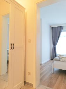 een witte deur in een kamer met een bed bij PEMATRA Haus Sonnenschein - FeWo Heimathafen in Travemünde