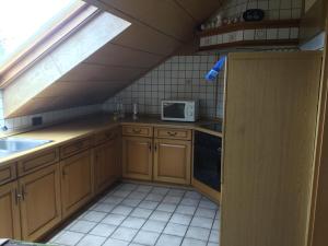 eine Küche im Dachgeschoss mit einer Spüle und einer Mikrowelle in der Unterkunft Alte Salzstraße 43 Ferienwohnung in Brietlingen