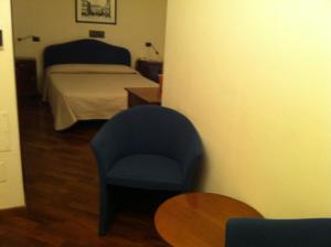 una camera con letto, sedia e tavolo di Hotel il Cigno a Perugia