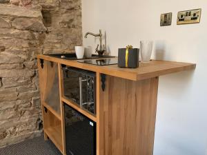 a kitchen with a wooden cabinet and a microwave at Royal Mile Suites by the Castle in Edinburgh