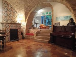 Le Foglie Di Acanto في لوتشرا: غرفة معيشة فيها بيانو ودرج