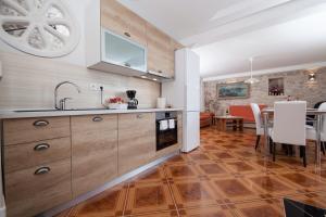 a kitchen with wooden cabinets and a dining room at VILLA FENIX PODGORA in Podgora