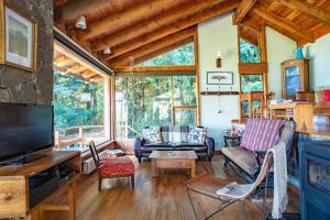 ein Wohnzimmer mit Möbeln und einem großen Fenster in der Unterkunft Colina Del Manzano in Villa La Angostura