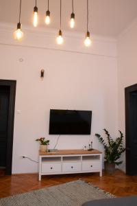 een woonkamer met een flatscreen-tv aan een witte muur bij Muresenilor 28 in Braşov