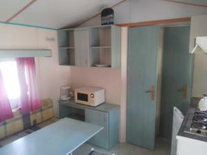 una pequeña cocina con mesa y microondas en camping Manex, en Saint-Pée-sur-Nivelle