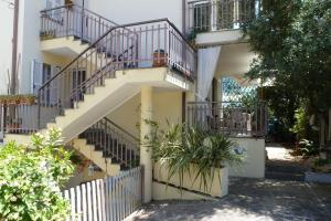 ein weißes Gebäude mit Treppen und Topfpflanzen in der Unterkunft La Martlona in Riccione
