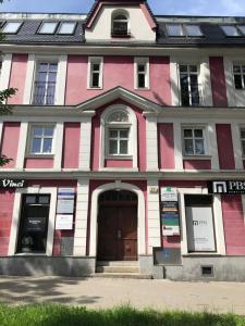 a pink and white building with a door at Bed4You in Zielona Góra