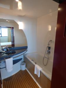 a bathroom with a bath tub and a sink at Novotel Suites Marseille Centre Euromed in Marseille