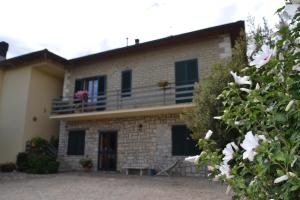 a brick house with a balcony and flowers at Affittacamere La Fornace in Rigomagno