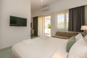 a bedroom with a large white bed and a couch at Iakinthos, Tsilivi Beach in Tsilivi