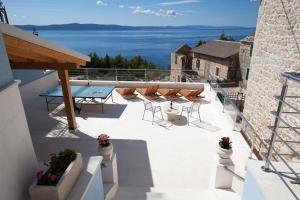 a patio with chairs and a table on a building at VILLA FENIX PODGORA in Podgora