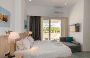 ein Hotelzimmer mit einem Bett und einem Sofa in der Unterkunft Iakinthos, Tsilivi Beach in Planos