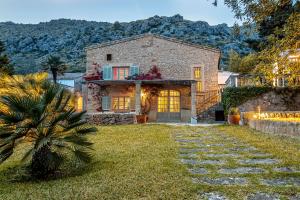 ポリェンサにあるVilla Can Segui By homevillas360の庭のヤシの木がある石造りの家