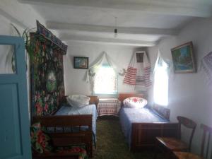 Cette petite chambre comprend 2 lits et une fenêtre. dans l'établissement Дибинецькі Карпати, à Dybintsy