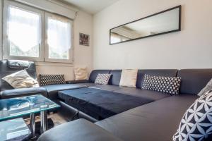 a living room with a couch and a table at DESIGN APARTMENT Near GENEVA in Étrembières