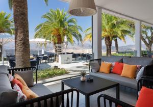 a living room with a couch and tables and palm trees at Catalonia Reina Victoria in Ronda