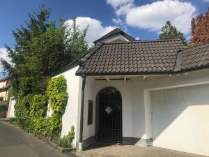 uma garagem branca com uma porta preta numa casa em Obere Kellerstraße Haus 2 em Forchheim