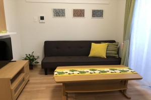 a living room with a black couch and a coffee table at TerraceRin YN12 in Tomigusuku