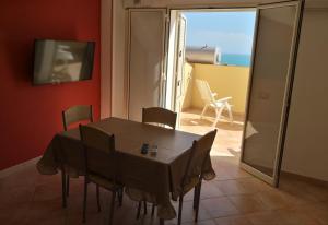 jadalnia ze stołem i krzesłami oraz balkonem w obiekcie Holiday Beach Lumia w mieście Sciacca