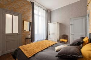 ein Schlafzimmer mit einem Bett und einem großen Fenster in der Unterkunft Le cœur de Reims, la mairie et le Boulingrin in Reims