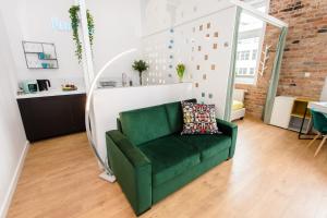a green couch in the middle of a living room at Bliss Apartments in Poznań