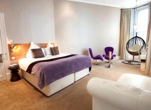 a bedroom with a bed and a chair and a couch at Carmelite Hotel in Aberdeen