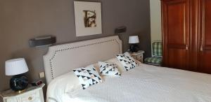 Un dormitorio con una cama blanca con almohadas. en Villa climatisée piscine privée classée 4 étoiles, en Laroque-des-Albères