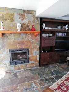 a living room with a stone fireplace at A Quinta da Colina ( Casinha ) in Castanheira de Pêra